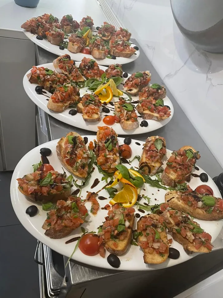 Platten mit frisch belegter Bruschetta, Oliven und Orangenscheiben